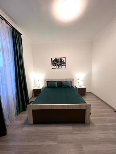 a bedroom with a bed and two lamps on two tables at Luxe Apartment Komitas in Yerevan