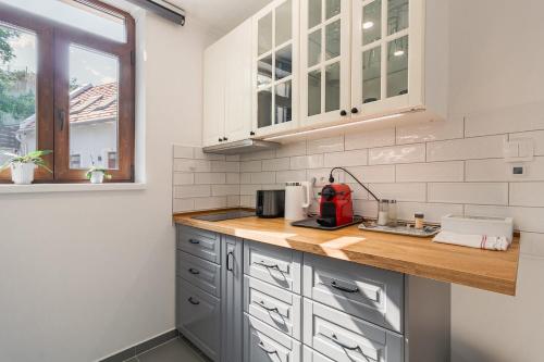 a kitchen with white cabinets and a wooden counter top at Monbuhim Twin in Veszprém