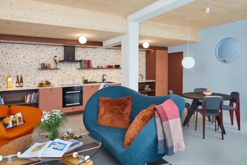 a living room with a blue chair and a table at Engelwirt Hotel & Apartments in Berching