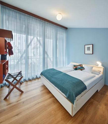 a bedroom with a large bed and a large window at Engelwirt Hotel & Apartments in Berching