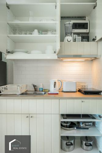 a kitchen with white cabinets and a sink at Studio Apartment by the Sea E413 in Phuket Town