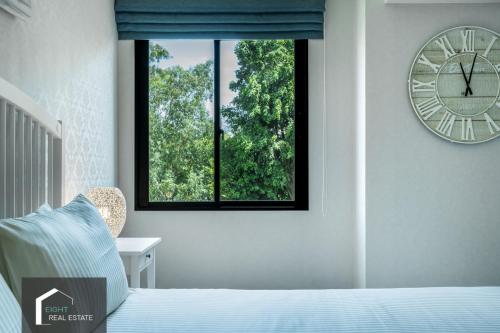 a bedroom with a clock on the wall and a bed at Studio Apartment by the Sea E413 in Phuket Town