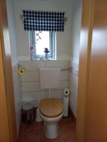 ein Badezimmer mit einer Toilette mit Holzsitz in der Unterkunft Ferienwohnung Großleiten Alm in Laaben