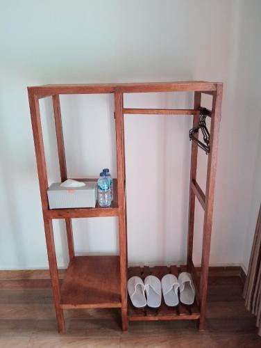 a wooden shelf with shoes on it next to a wall at Jepun Homestay Lemukih in Singaraja