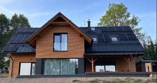 a house with solar panels on the roof at Chalupa Jestřabí in Jestrabi V Krkonosich