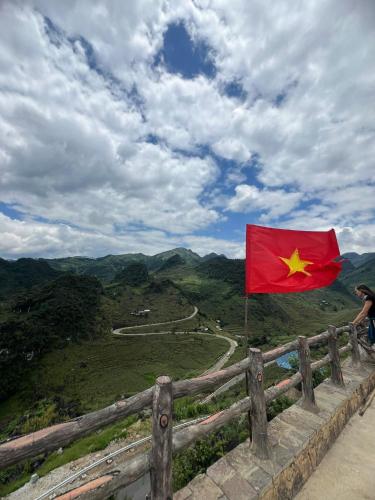 a flag on a fence with a view of a mountain at Strawberry House , Tour & Motorbikes Rentel in Ha Giang