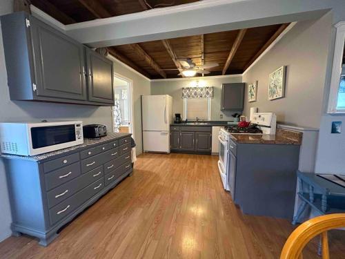 a kitchen with gray cabinets and a white refrigerator at The Tides At Hampton Beach in Hampton
