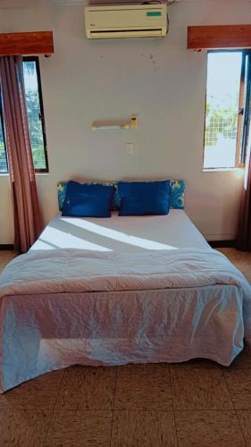 un grande letto con cuscini blu in una camera da letto di Singhs Apartment, Gray road lot 19 Matintaar Nadi, Mountain view a Nadi