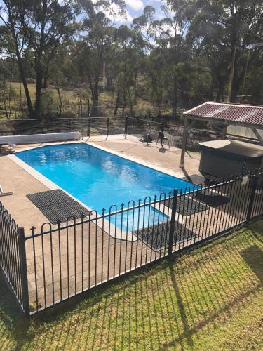 a fence around a swimming pool in a yard at Yarrabin Retreat in OʼConnell