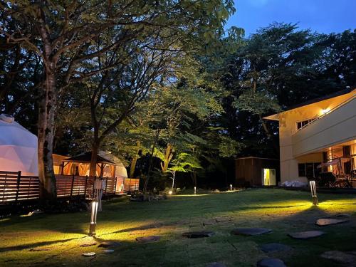 a yard with a building and a tree at night at ドゥカーレリゾートホテル那須甘露の湯 in Nasu-yumoto