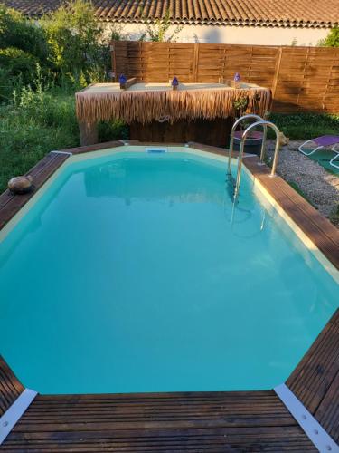 une piscine avec une terrasse en bois et une piscine dans l'établissement Gîtes Casa No-Na, à Flayosc