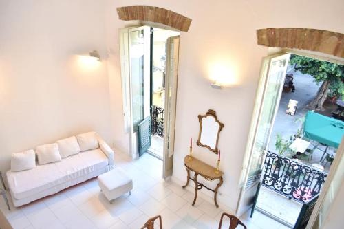 a living room with a couch and a balcony at Sinclair , loft in center with original romantic fresco in Cagliari