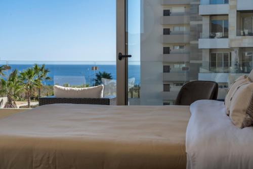 a bedroom with a bed and a view of the ocean at Luxury Beachfront Apartment in Cabo in Cabo San Lucas