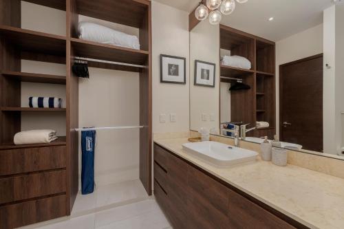 a bathroom with a sink and a mirror at Luxury Beachfront Apartment in Cabo in Cabo San Lucas