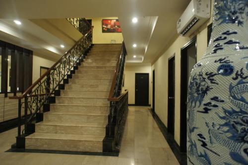 a staircase in a building with a blue and white vase at Sky View Hotel Managed by OS in Batam Center