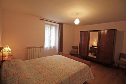 a bedroom with a bed and a dresser and a window at Champblanc in Arnac-la-Poste