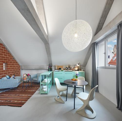 a kitchen and living room with a table and chairs at Engelwirt Hotel & Apartments in Berching