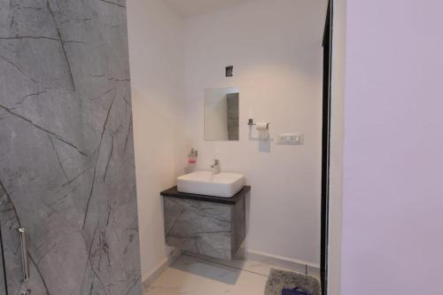 a bathroom with a sink and a shower at Hari Home Stay in Garudeshwar