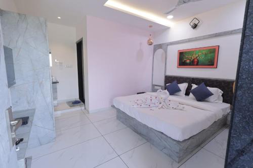 a bedroom with a large bed and a bathroom at Hari Home Stay in Garudeshwar