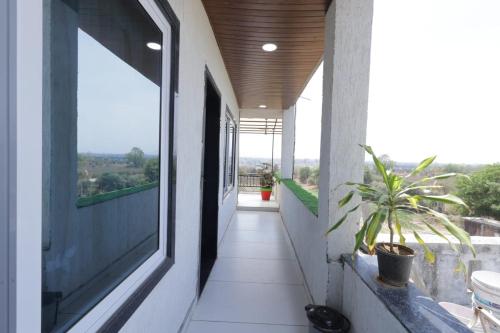 a hallway of a house with a window and a plant at Hari Home Stay in Garudeshwar