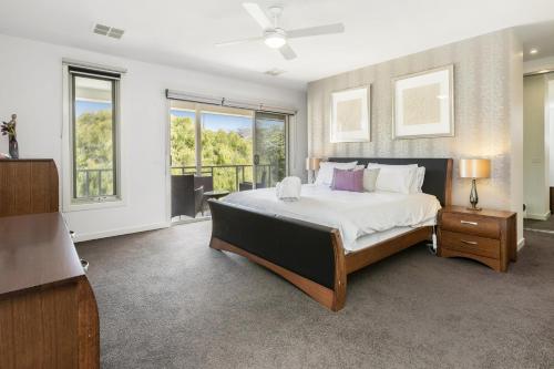 a bedroom with a large bed and a balcony at Tyrone Beachside Luxury - Home Theatre Study in Rye