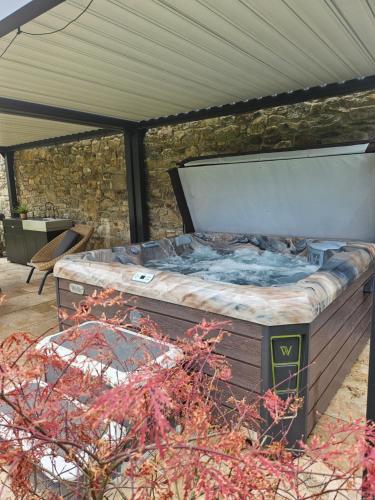 a hot tub sitting on top of a patio at GÎTE L'anglais, appartement privé en Duplex avec accès Jacuzzi à 10min des plages in Lanhouarneau