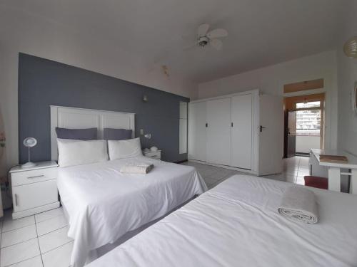 a bedroom with two white beds and a blue wall at Unit 606 Seabrook in Margate