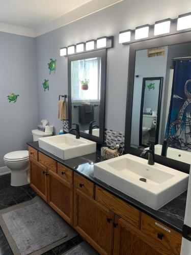 een badkamer met 2 wastafels en een toilet bij Best Bed and Breakfast in Port Alberni