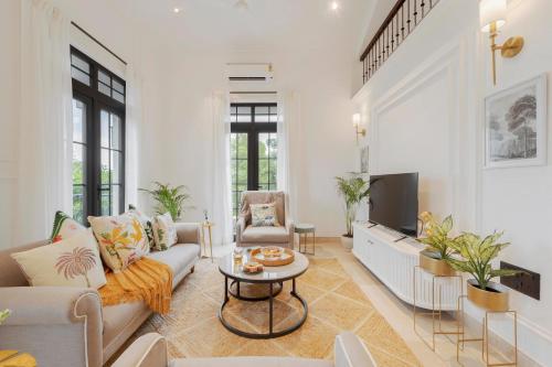 MarnaにあるGrosvenor House by Hireavilla - 3BHK Duplex with Pool in Assagaoのソファとテレビのあるリビングルーム