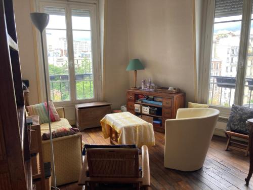 un salon avec une chaise et une table dans l'établissement Paris Tour Eiffeio, cœur des JO, à Paris