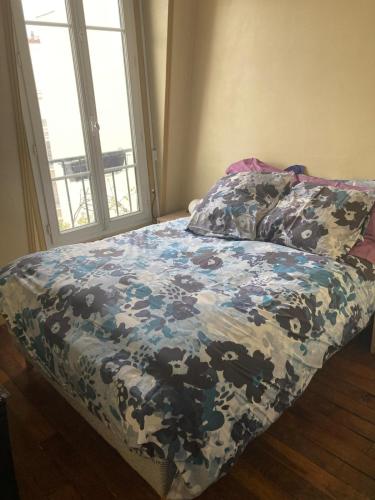 - un lit dans une chambre avec une couverture dans l'établissement Paris Tour Eiffeio, cœur des JO, à Paris