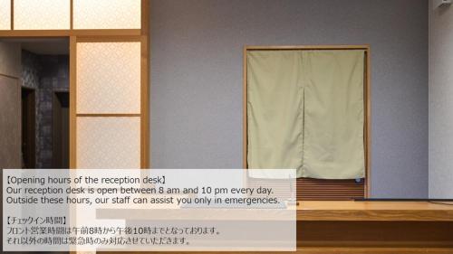 a room with a partition with a curtain and a sign at Hotel GOCO stay Kyoto Shijo Kawaramachi in Kyoto