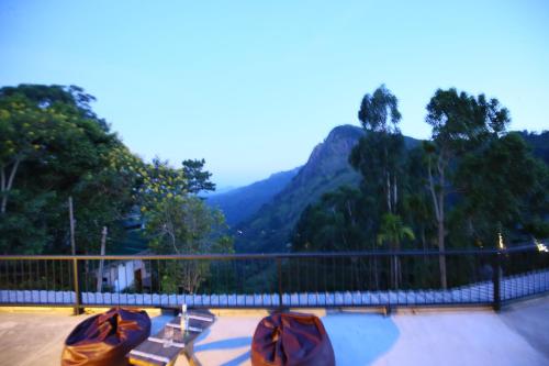 two benches on a patio with a view of a mountain at Beyond Nomad Luxury Hostel in Ella