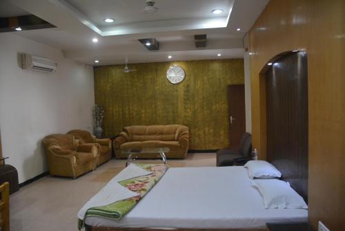 a bedroom with a bed and a living room with couches at Hotel Naveen Residency in Darbhanga