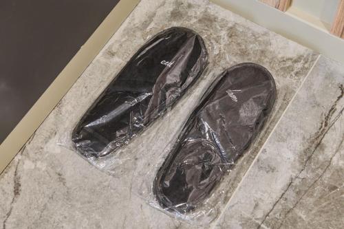 a pair of shoes wrapped in plastic on a marble floor at Five Business-class rooms in R-house near Mega Center Almaty in Almaty
