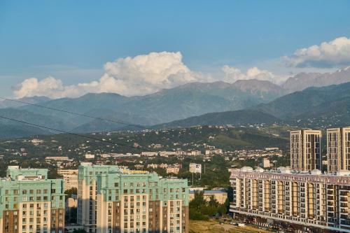 a view of a city with buildings and mountains at Five Business-class rooms in R-house near Mega Center Almaty in Almaty