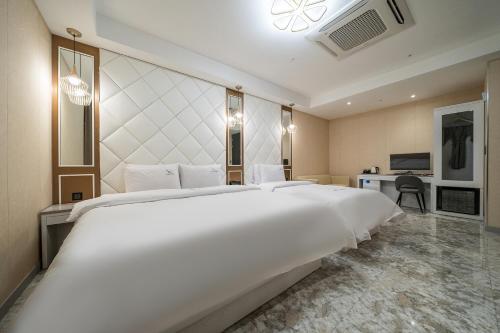 a large white bed in a hotel room at Hotel Voll in Seoul