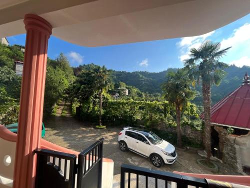 a white car parked on a balcony with palm trees at Home in paradise in Tofaloglebi