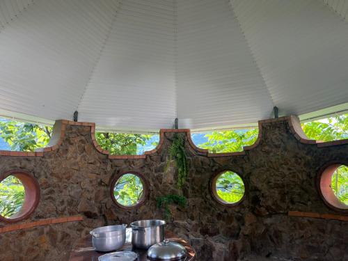 a kitchen with pots and pans on a table with windows at Home in paradise in Tofaloglebi