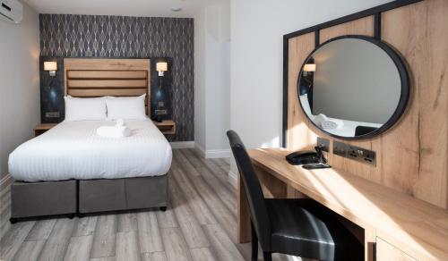 a bedroom with a bed and a mirror and a desk at Best Western Chiswick Palace & Suites London in London