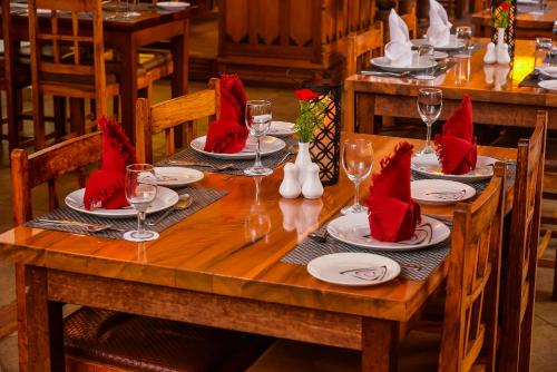 a wooden table with red napkins and glasses on it at Destiny - The Farm Resort in Ooty