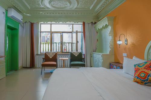 a bedroom with a large bed and a table and chairs at 达卜·九宿民宿 in Turfan