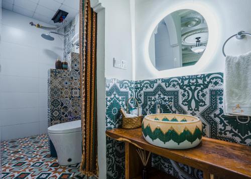 a bathroom with blue and white tiles and a mirror at 达卜·九宿民宿 in Turfan