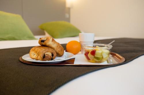 a tray with a plate of food and fruit on a table at Hotel inn Design Laval in Laval