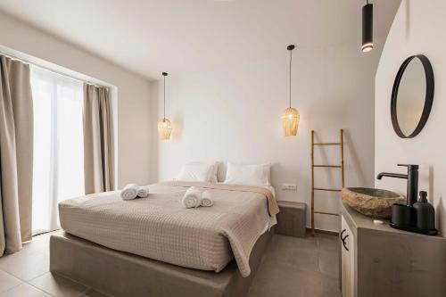 a bedroom with a bed with two towels on it at Kouros Exclusive Hotel & Suites - Adults Only in Faliraki