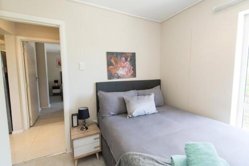 a bedroom with a bed and a chair at The Pearls 3b Luxury Apartment in Summerstrand