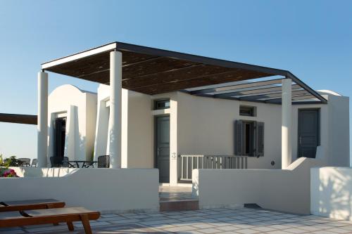 a white house with awning on a patio at Xenones Filotera in Imerovigli