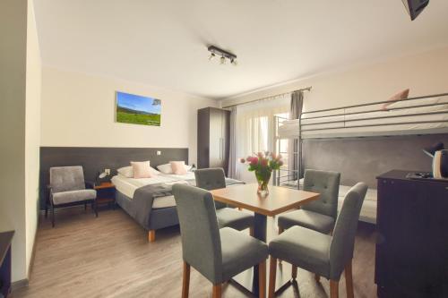 a hotel room with a bed and a table and chairs at Willa Luiza in Wisła