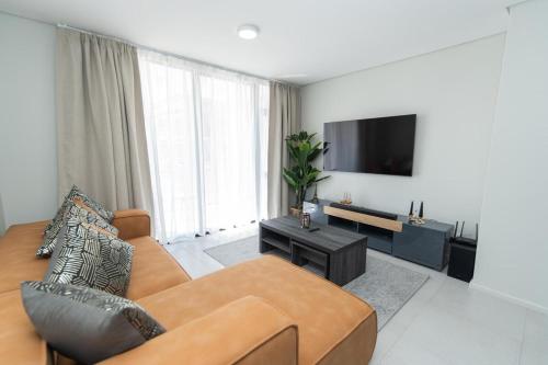 een woonkamer met een bank en een flatscreen-tv bij Bella Retreat Bellamare in Summerstrand