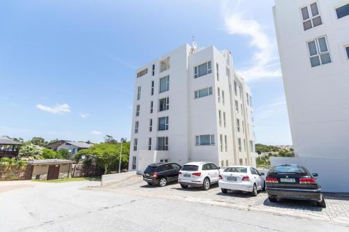 a white building with cars parked in front of it at The Pearls 3b Luxury Apartment in Summerstrand